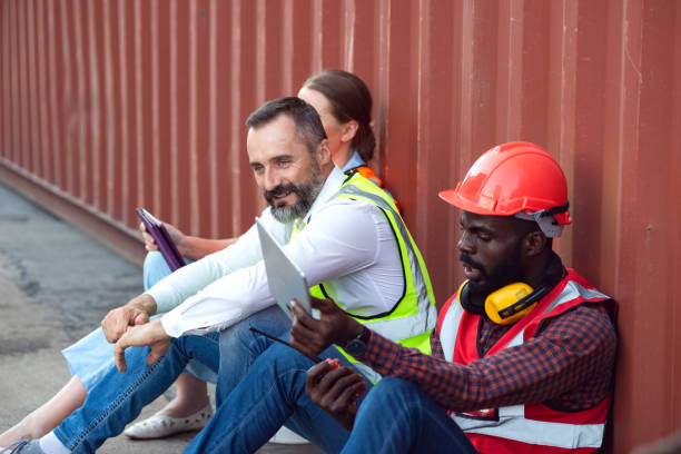 istock Two manager and one engineer sit and discuss about their job for shipment to customer. Distribution storage commerce port cargo. 1400194944