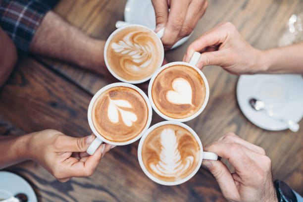 Cappuccino art Above view of hands holding cappuccino cups latte stock pictures, royalty-free photos & images