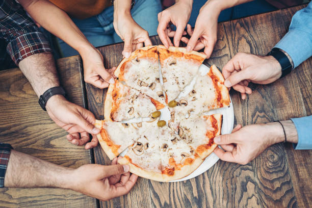 istock Above view of hands reaching for pizza slices 1400194994