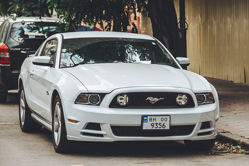 Odessa, Ukraine - September 5, 2021: White Ford Mustang parked in the city. American muscle car