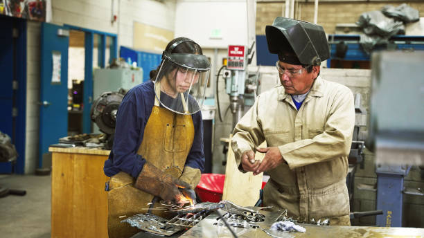 weiblicher teenager, der mit seinem lehrer metallarbeiten lernt - navajo national monument stock-fotos und bilder