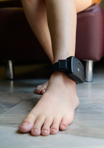 Prisoner is attached to an electronic monitoring on ankle.
