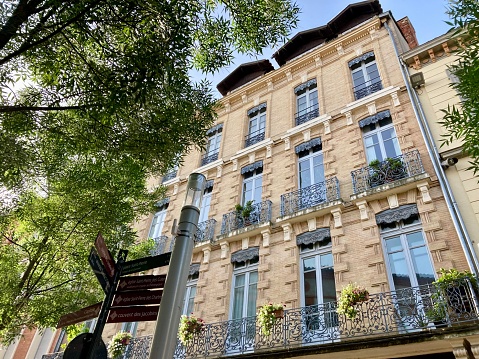 France - Toulouse - buildings in the city center, typical, with their facade decorated with wrought iron balconies and pastel colors, light