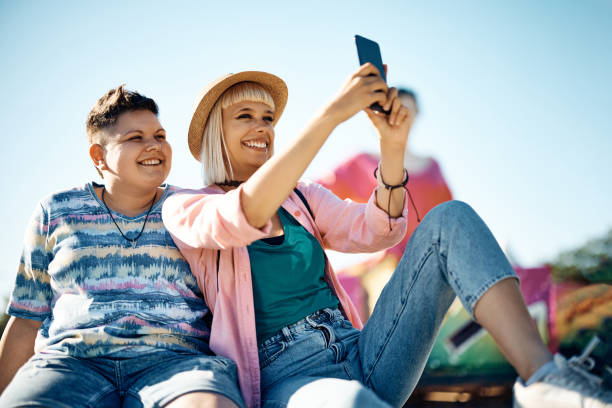 istock Happy female friends taking selfie while having fun at amusement park. 1400200473