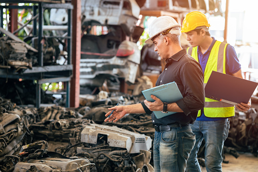 Engineer foreman manager working checking stock with young male staff worker