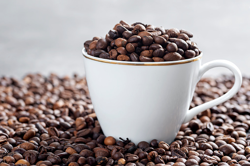 Coffee beans and cup on textured background