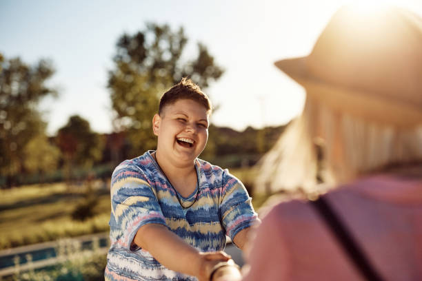 istock Cheerful lesbian holding hands with her girlfriend while spinning in nature. 1400201911
