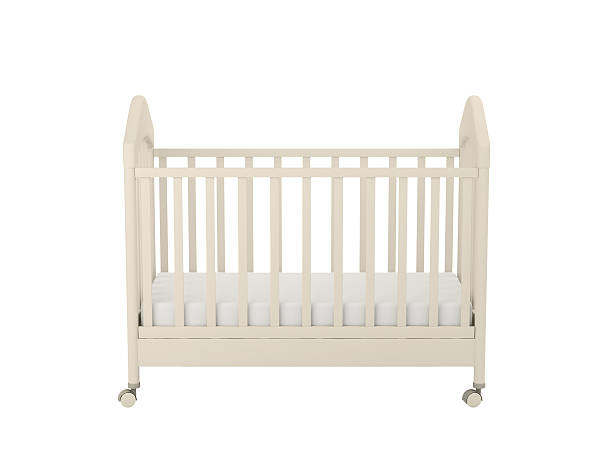 A plain cream colored crib with wheels White cot isolated on a white background crib photos stock pictures, royalty-free photos & images