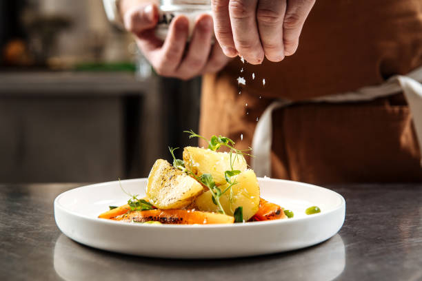 istock Chef's hand sprinkles cooked dish with salt 1400207252