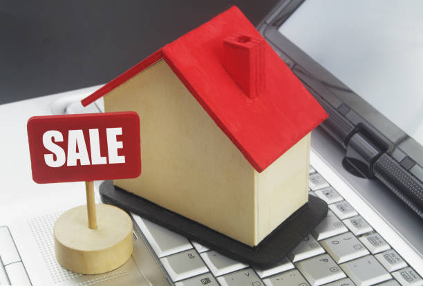 istock Wooden house model and banner SALE on computer keyboard. 1400208658