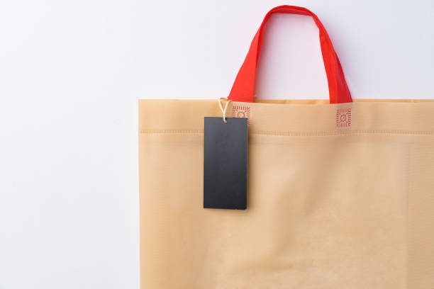 istock Blank paper tag with shopper paperbag on white background, close up 1400209780