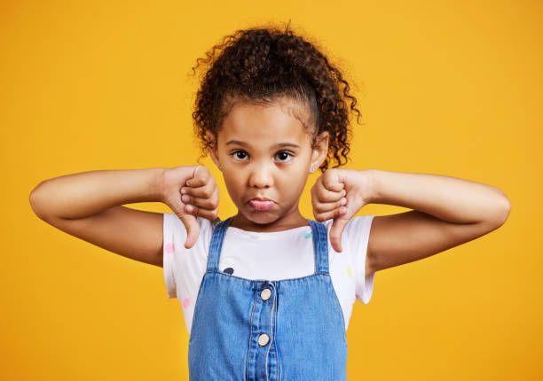 Studio portrait mixed race girl giving thumbs 
down isolated against a yellow background. Cute hispanic child posing inside. Unhappy and upset kid being negative and saying, I disagree or disapprove Studio portrait mixed race girl giving thumbs 
down isolated against a yellow background. Cute hispanic child posing inside. Unhappy and upset kid being negative and saying, I disagree or disapprove thumbs down stock pictures, royalty-free photos & images