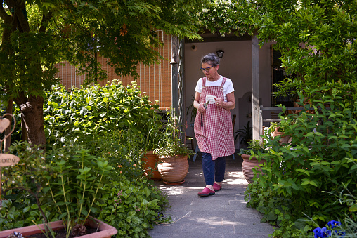 A middle-aged lady happily works in the garden of her house when, at the end of April beginning of May, it is the moment in which she reaches her peak.
