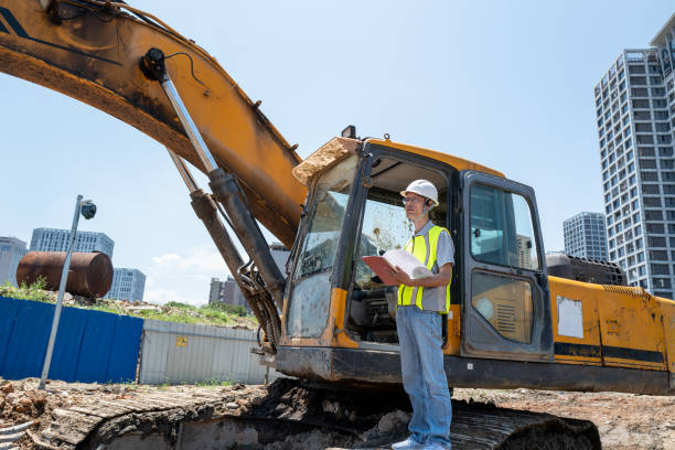 istock Male engineer next to construction machinery at construction site 1400211753