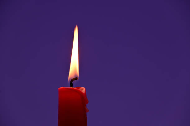 istock Burning red candle against a violet background 1400213308