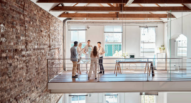istock Group of diverse architects discussing plans, blueprints and schematics during a meeting in their office boardroom. Business people brainstorming and planning their upcoming project development 1400214986