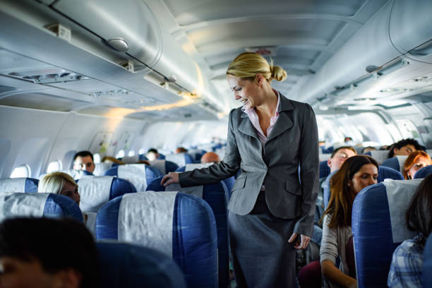 istock Happy female flight attendant talking to passenger in a plane. 1400216065