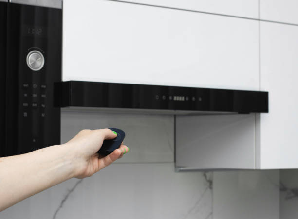 istock Modern black range hood in a white kitchen with remote control from a distance. Close-up 1400216530