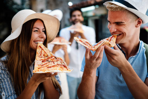 istock Group of friends eating pizza while traveling on vacation 1400218708