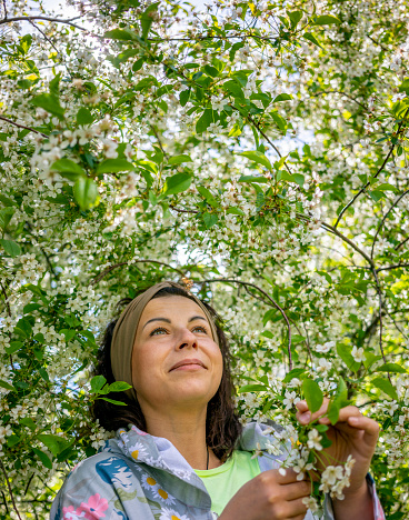 Portrait of beautiful brunette woman with blooming cherry tree