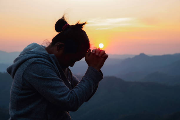 woman praying, Silhouette of christians woman praying, spirituality and religion, woman praying to god. Christianity concept. church like a holy light from god stock pictures, royalty-free photos & images