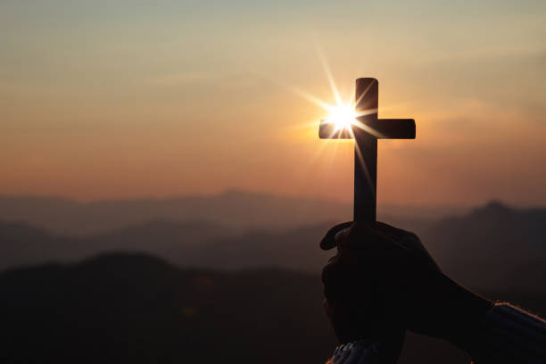 istock silhouette hand holding cross 1400223436