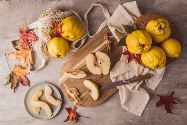 Ripe whole and sliced quinces. Fresh fruit for preparing recipes with cinnamon and lemon. An essential ingredient for a healthy diet