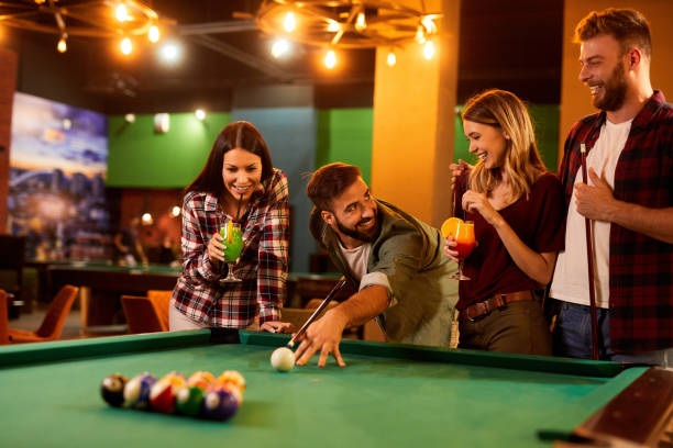 istock Group of friends having fun while playing pool in a local pool hall 1400228669