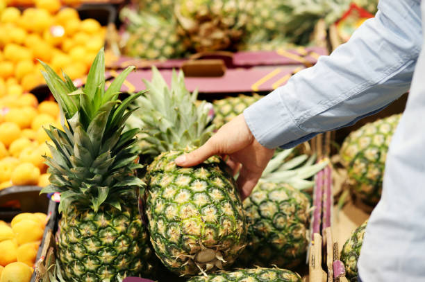 istock Man buying  pineapple at the market 1400230097