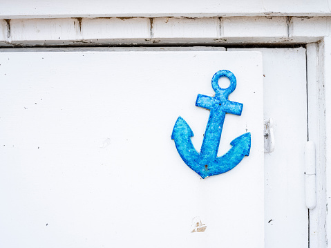 A marine anchor hanging on a beach hut