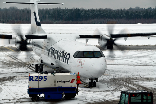 Helsinki, Finland: Finnair ATR 72-500 (72-212A) registration OH-ATF, MSN 744 and snow covered tarmac - starting engines in icy weather with the help of a Huffer Cart, an Air Start Unit (ASU) - Helsinki-Vantaa Airport, the main international airport of the city of Helsinki. The ATR 72 is a turboprop regional airliner for short-haul cargo and passenger services manufactured by the Franco-Italian consortium 'Avions de Transport Régional'. It was developed from the shorter ATR 42.