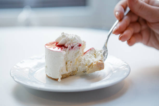 istock Red and white cake being cut with fork in female hand. 1400235966