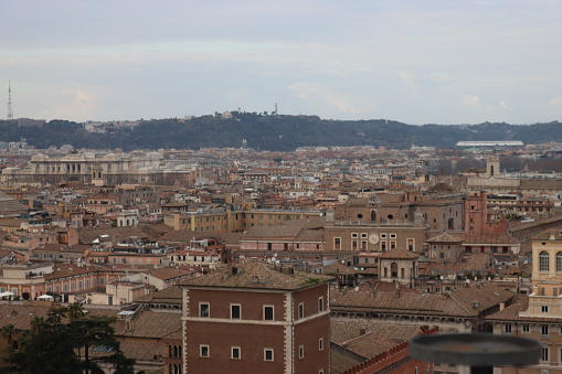 ROME, ITALY - February 05, 2022: Rome, Italy aerial view towards the city of Rome and the archeological areas at sunset. Cold and grey sky in the background. Roman Forum viewed from the capitoline hill.