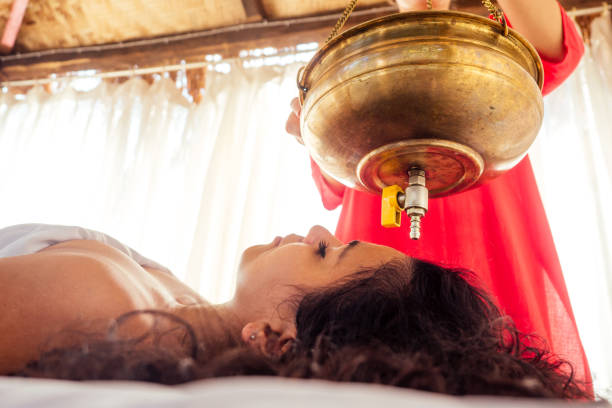 jeune femme faisant des soins de santé traitement traditionnel indien dans le centre de constitution du corps ayurvédique - ayurveda massaging aromatherapy chakra photos et images de collection