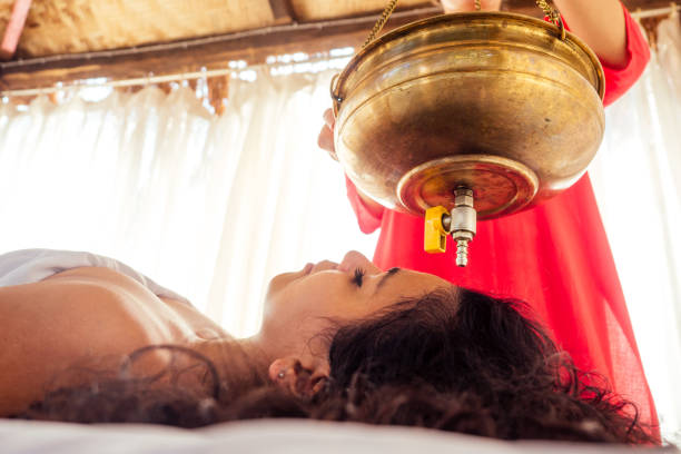 young woman doing healthcare indian traditional treatment in ayurveda body constitution centre - ayurveda massaging aromatherapy chakra imagens e fotografias de stock