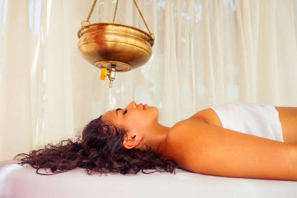 young woman doing healthcare indian traditional treatment in ayurveda body constitution centre - ayurveda massaging aromatherapy chakra imagens e fotografias de stock