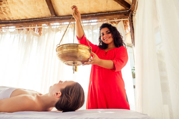 jeune femme faisant des soins de santé traitement traditionnel indien dans le centre de constitution du corps ayurvédique - ayurveda massaging aromatherapy chakra photos et images de collection