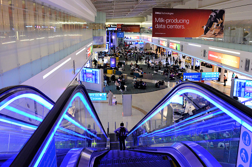 Dubai, United Arab Emirates: view from an escalator top of  Terminal 1, Concourse D - Dubai international airport - blue lights. The airport is home to Emirates , the international airline of the Emirates of Dubai, and serves as a hub in its route network.