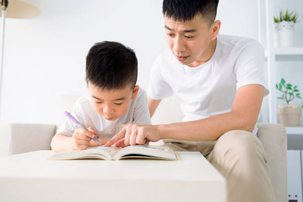 istock Father helping child doing homework at home 1400248026