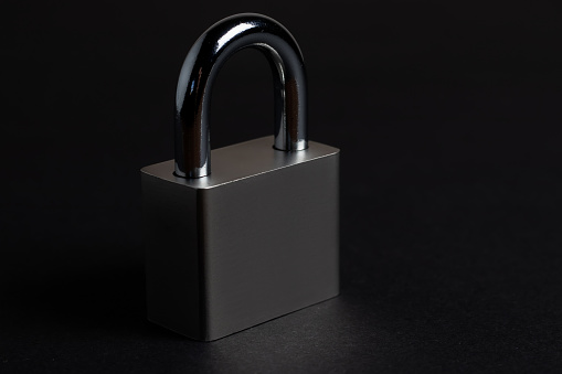 Steel padlock on the black textured background.