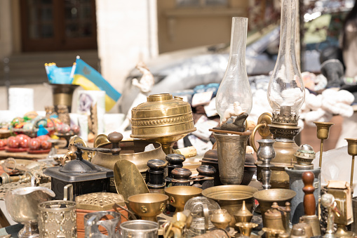 Different antiques on flea market or traditional festival - vintage lamps and other vintage things. Collectibles memorabilia or garage sale concept