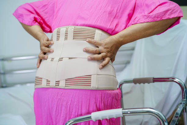 istock Asian senior pain back wearing elastic support belt with walker. 1400254875