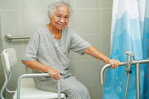 asiatique âgée femme âgée patient utiliser toilette rail de support dans la salle de bain, barre d’appui de sécurité main courante, sécurité dans l’hôpital de soins infirmiers. - senior adult women adult tan photos et images de collection