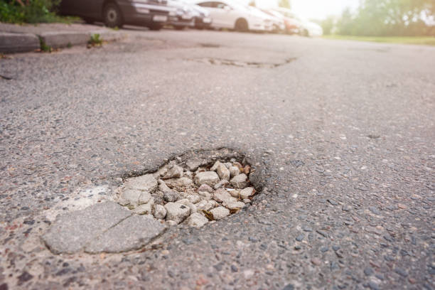 istock Pothole filled with pebbles on asphalt road in city. 1400255586