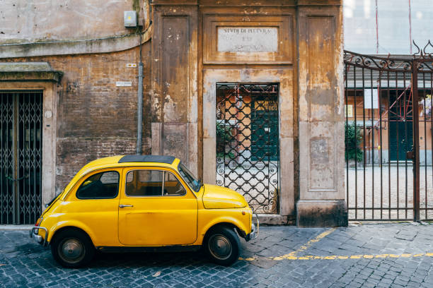 ローマの通りは、旧市街に駐車された小さな車でよく知られています - ベスパ ストックフォトと画像