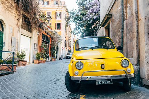 rome, italy. 17th april, 2022: a classic fiat 500 vehicle is parked in roman street