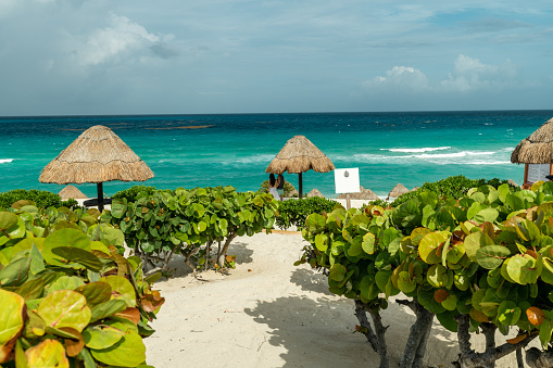 young hispanic couple in the distance enjoy the caribbean in cancun