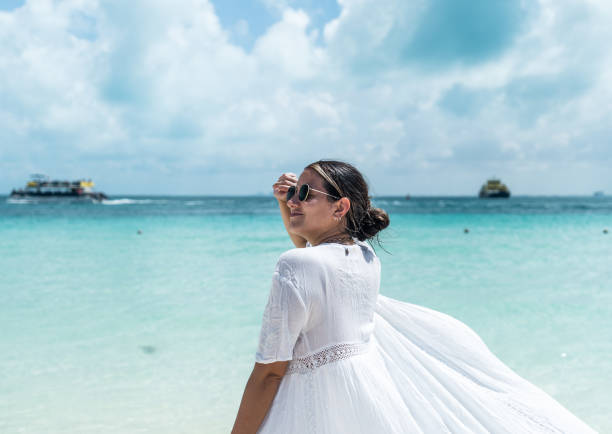 young hispanic woman from the back looks to the side in the caribbean sea young hispanic woman from the back looks to the side in the caribbean sea isla mujeres stock pictures, royalty-free photos & images