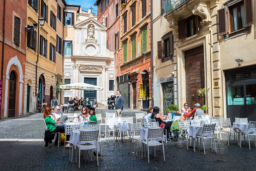 rome, italy. 12th april, 2022: people relaxing outside a cafe in trastevere district