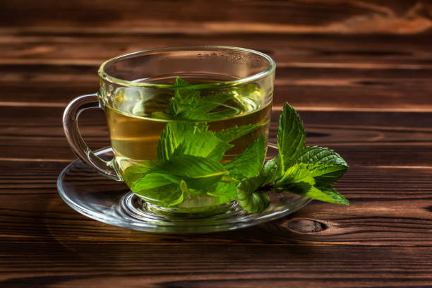 istock Cup of mint tea and a bunch of mint on the table 1400256768